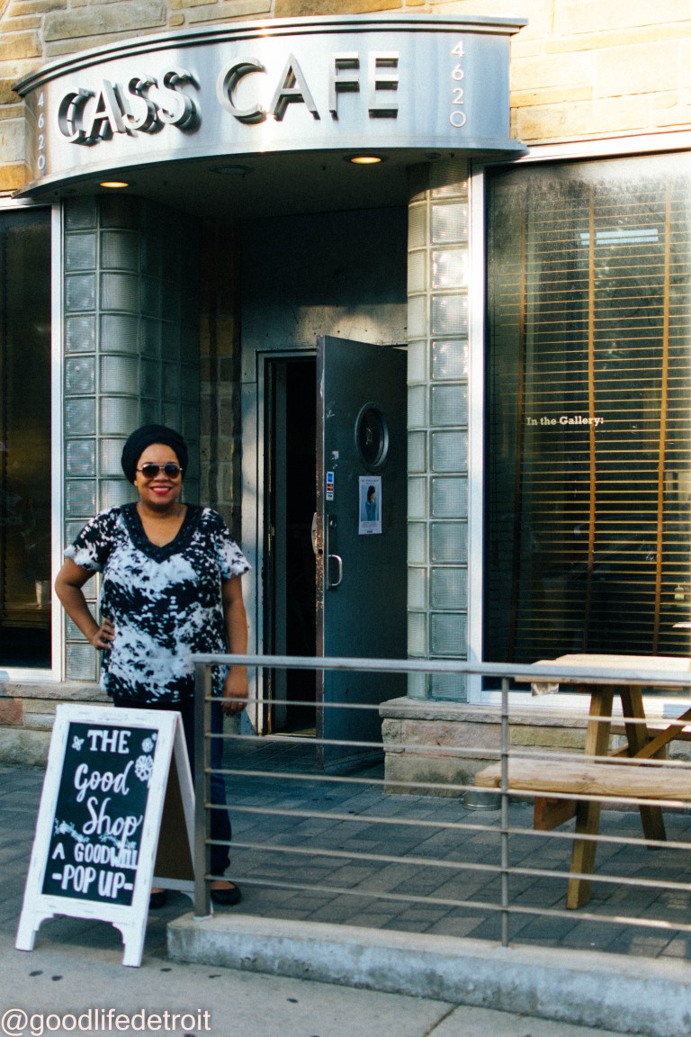 Woman standing outside the cafe entrance.